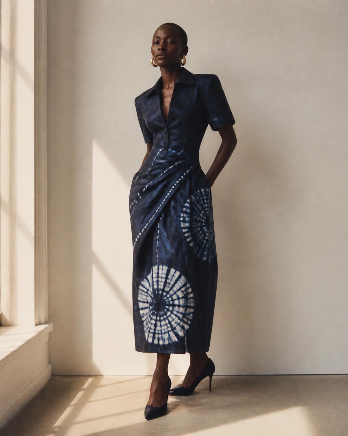 Model wearing a hand-dyed indigo adire shirt dress in natural light